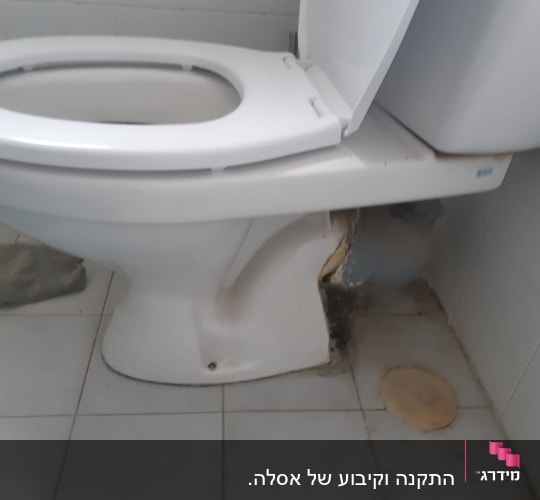 אסלה עם נזילה בצנרת וכתמי רטיבות